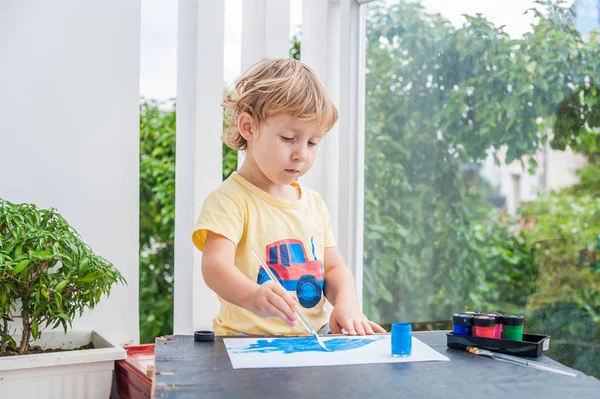 Kleiner Junge malt mit bunten Farben — Stockfoto