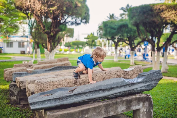 Хлопчик піднімається на кам'яні блоки — стокове фото