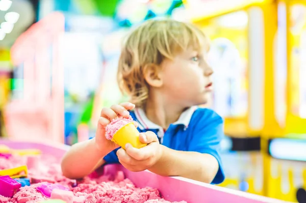 Junge spielt mit kinetischem Sand — Stockfoto