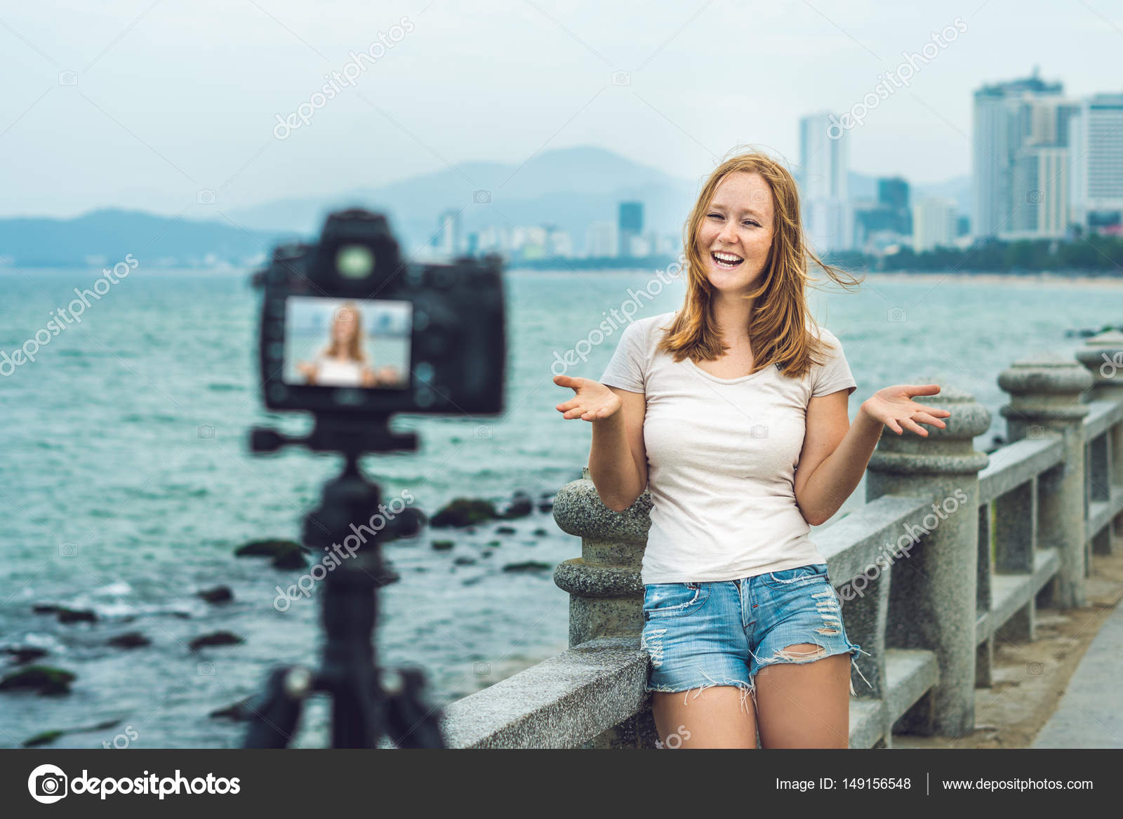 девушка блогер перед камерой. девушка фотограф на пляже. сняла море на камеру.