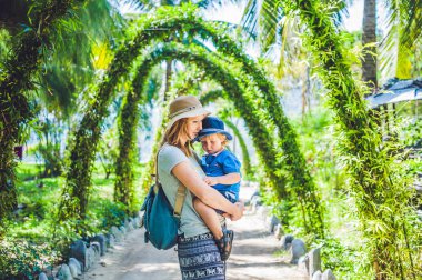Anne ve oğlu bir tropik bahçe