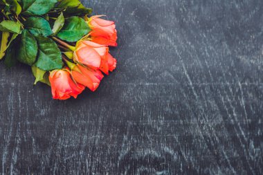 Eski ahşap bir masada kırmızı güller