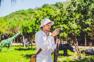 Adam parkta bir tripod üzerinde kamera ile vuruyor. kavram filme