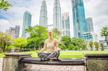 Genç bir kadın parkta meditasyon yapıyor. 