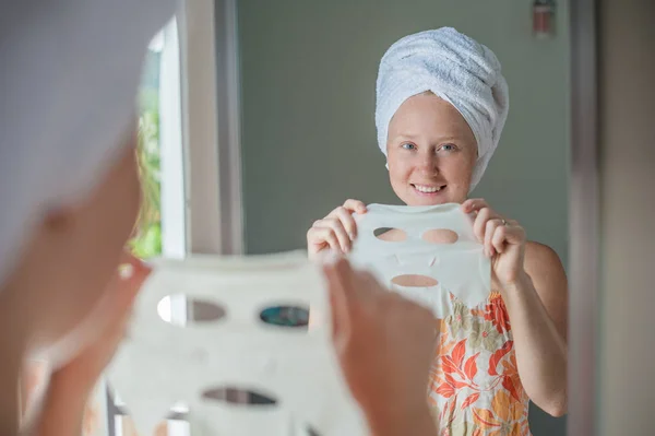 Woman doing facial mask sheet — Stock Photo, Image