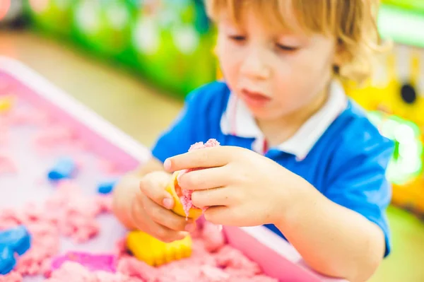 Junge spielt mit kinetischem Sand — Stockfoto