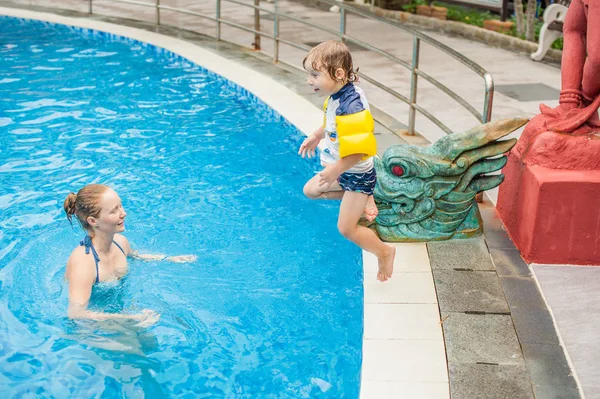 Menino saltar para a água da piscina . — Fotografia de Stock