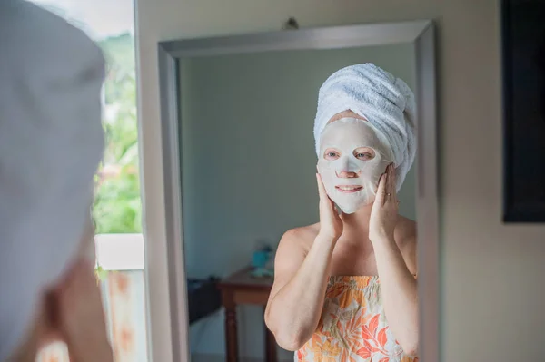 Mujer haciendo mascarilla facial hoja — Foto de Stock