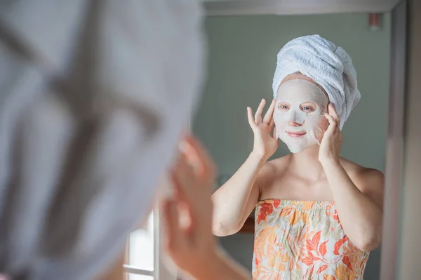 Femme faisant la feuille de masque facial — Photo
