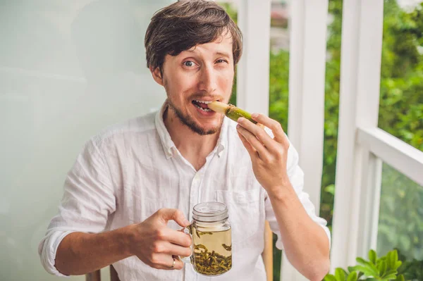 Человек в шутку ест сахарный тростник — стоковое фото