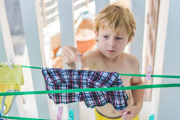 Niño colgando ropa — Foto de Stock