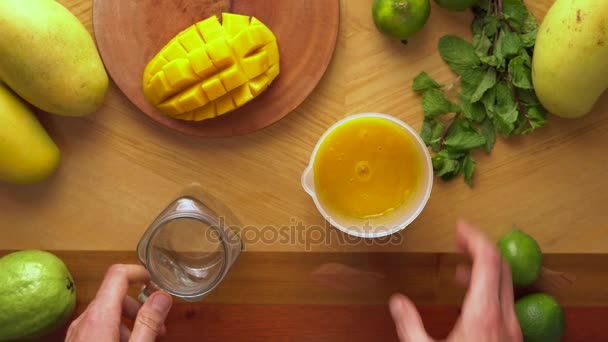 Человек с сочным коктейлем из манго — стоковое видео