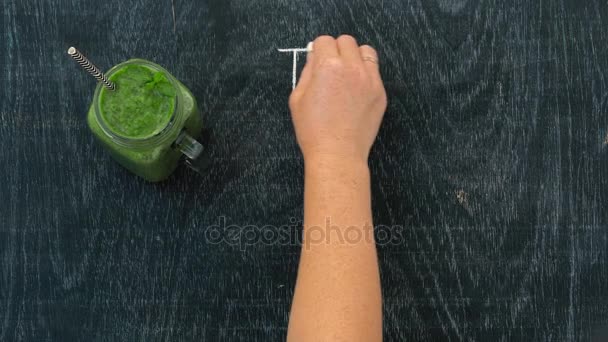 Hand med krita och grön smoothie — Stockvideo