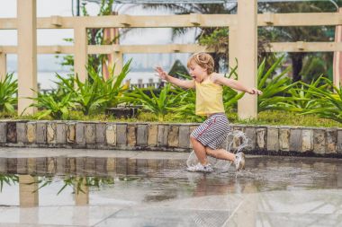 Küçük çocuk bir su birikintisi ile çalışır. 