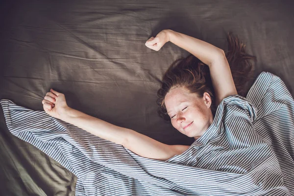 Wanita muda berbaring di tempat tidur — Stok Foto