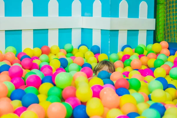 Niño jugando en coloridas bolas de plástico —  Fotos de Stock