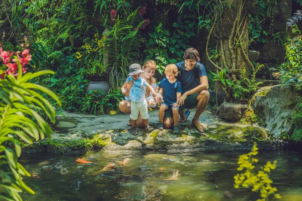 Happy family feeding colorful Catfish — Stock Photo, Image