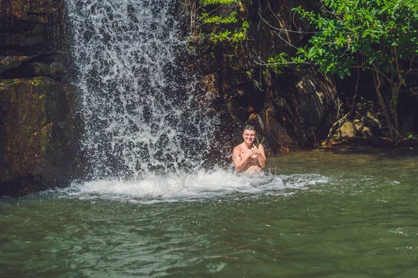 Mann mit Armen gegen Wasserfall. — Stockfoto