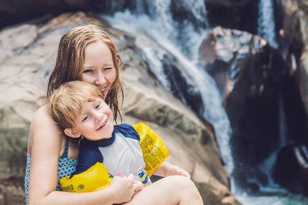 Matka a mladý syn na pozadí vodopád. — Stock fotografie