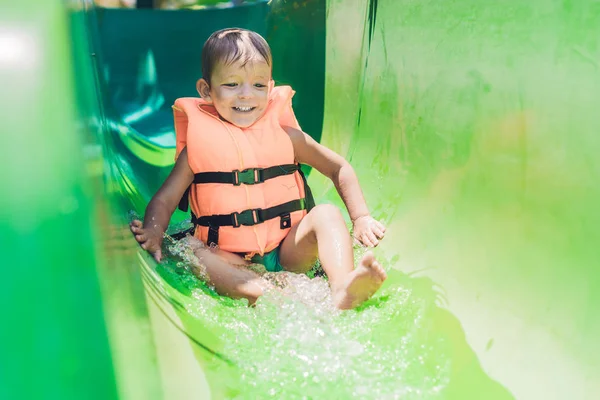 Boy  slides down from a slide — Stock Photo, Image