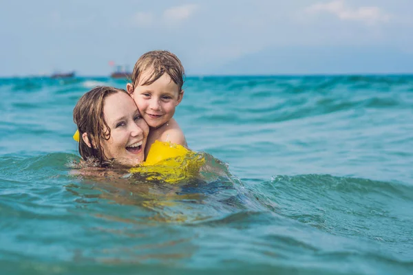 Junge Mutter schwimmt mit Kind — Stockfoto