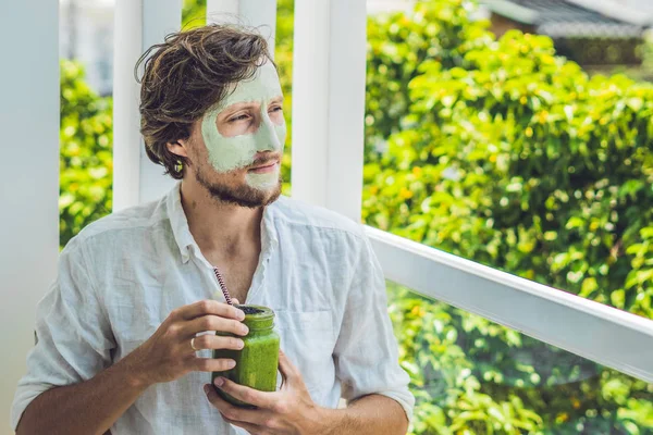 Férfi zöld agyaggal maszk és smoothie — Stock Fotó