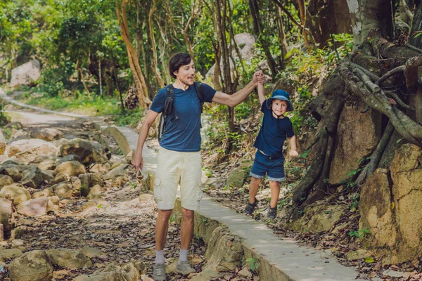 Отец и сын гуляют по лесу — стоковое фото