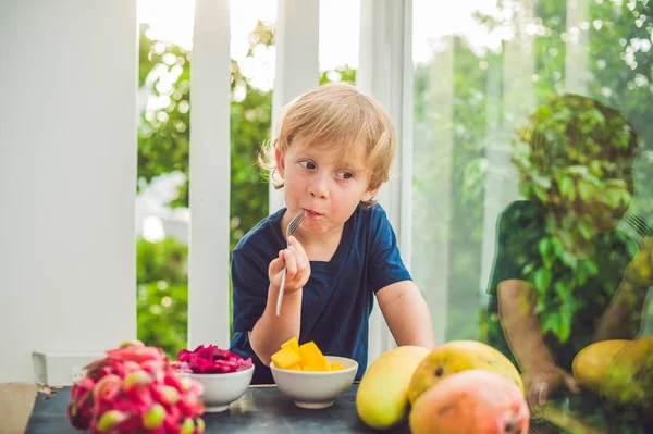 Little cute boy eating mango