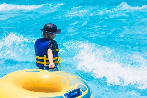 Boy is riding on an inflatable donut — Stock Photo, Image