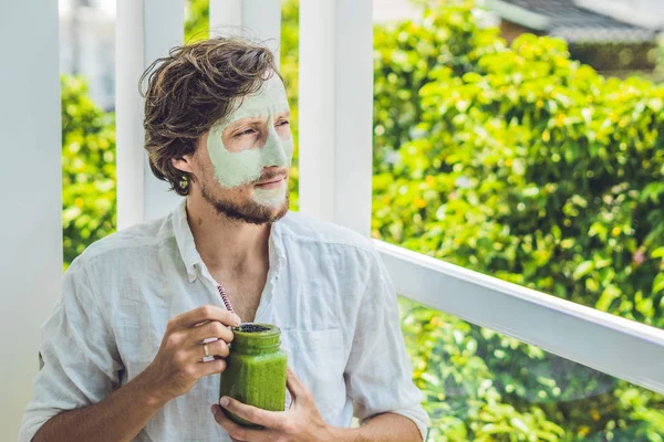 man with green clay Mask and  smoothie