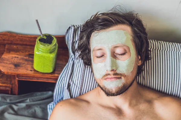 Homem aplicando máscara de barro verde — Fotografia de Stock