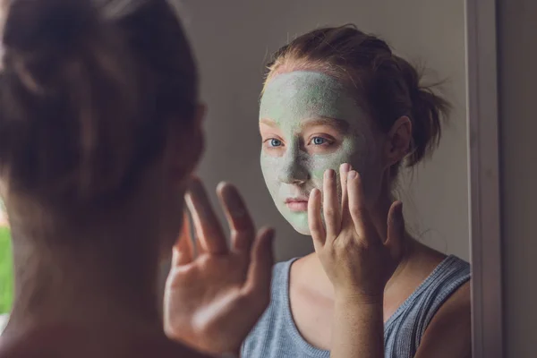 Mujer aplicando Facial máscara de arcilla verde — Foto de Stock