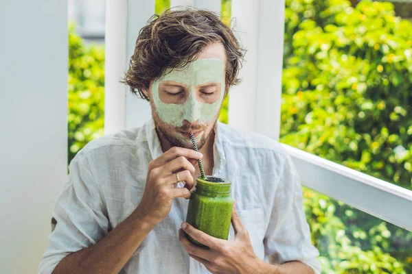 man with green clay Mask and  smoothie