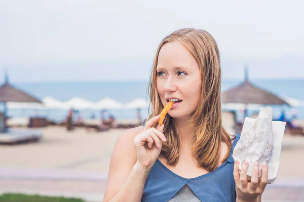 Woman eat fried sweet potatoes — Stock Photo, Image