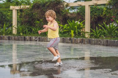 Küçük çocuk bir su birikintisi ile çalışır