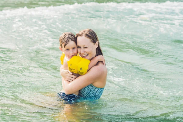 Giovane madre nuotare e giocare con il bambino — Foto Stock