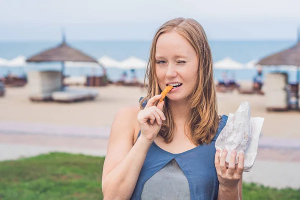 Woman eat fried sweet potatoes — Stock Photo, Image