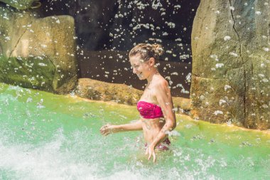 Genç kadın bir şelale altında rahatlatıcı 