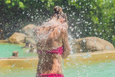 Genç kadın bir şelale altında rahatlatıcı 