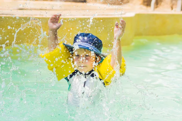 Rapaz feliz salpicando água ao redor — Fotografia de Stock