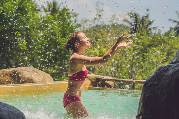 Young woman relaxing under a waterfall — Stock Photo, Image