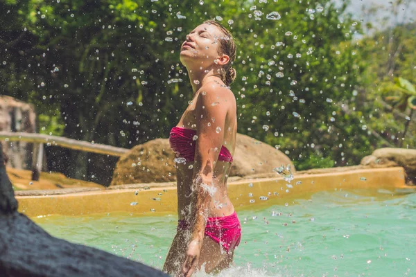 Young woman relaxing under a waterfall — Stock Photo, Image