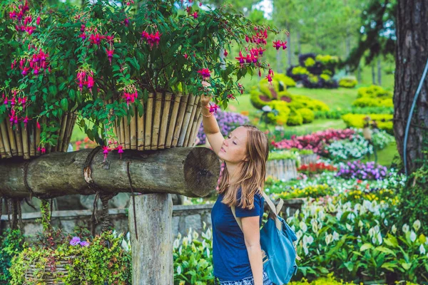 Щаслива жінка насолоджується запахом квітів — стокове фото
