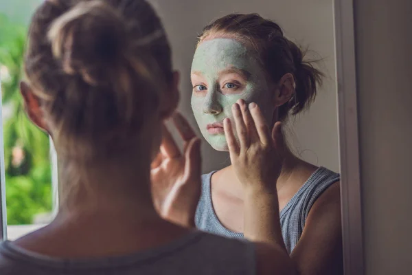 Hermosa chica aplicando máscara facial . — Foto de Stock