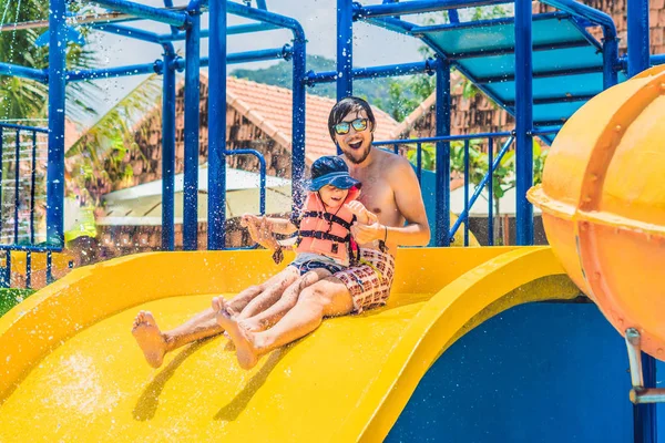 Father and son on a water slide — Stock Photo, Image