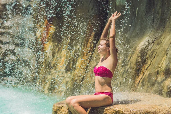 Young woman relaxing under a waterfall — Stock Photo, Image