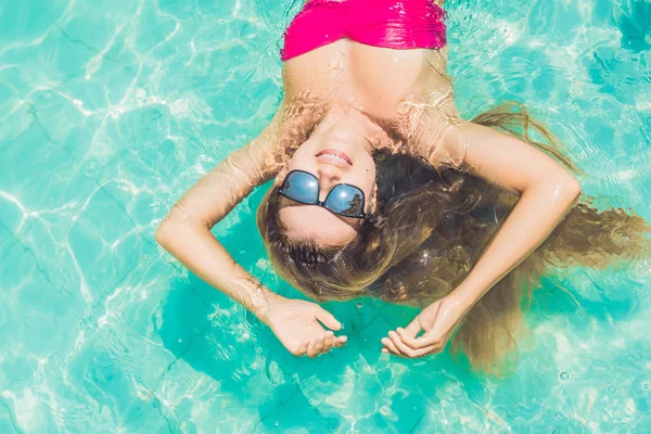 Jovem flutuando na piscina — Fotografia de Stock