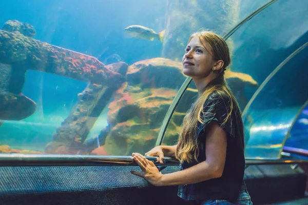 Jovem mulher olhando para peixes — Fotografia de Stock