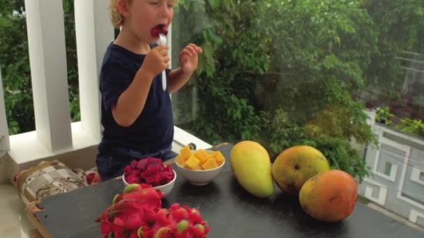 Little cute boy eating mango — Stock Video