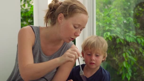 Pojken och hans mamma äter drakfrukt — Stockvideo